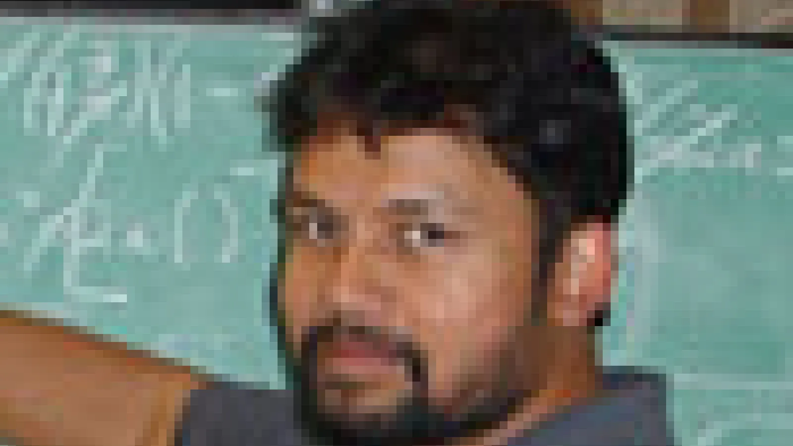 Prof. Chowdhury writing on a large chalkboard