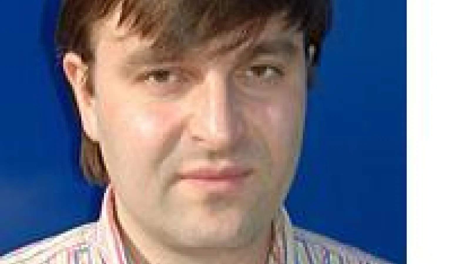 Ivan I. Smalyukh against bright blue background