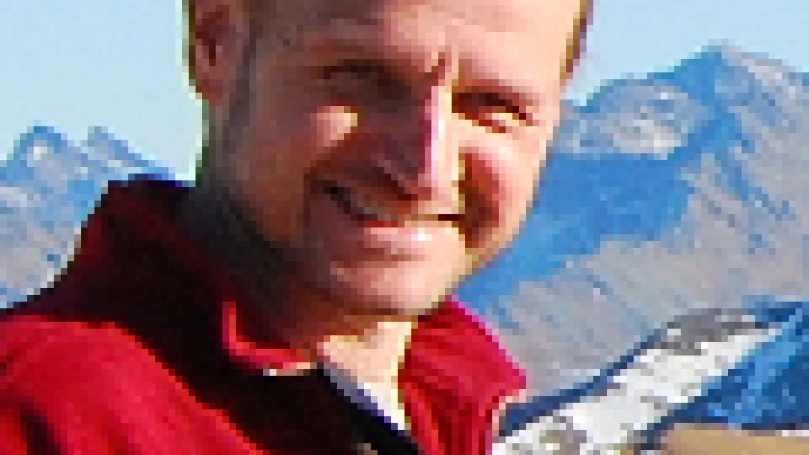Maciej Maska smiling with mountain range behind him