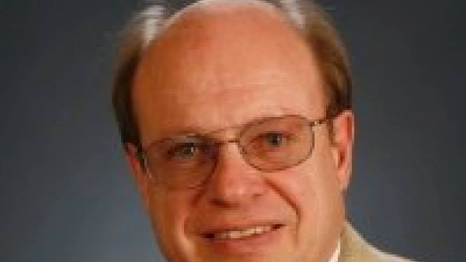 A headshot of Ulrich Heinz with a grey background.