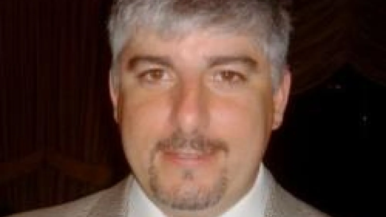 Chris Hill in suit with black background