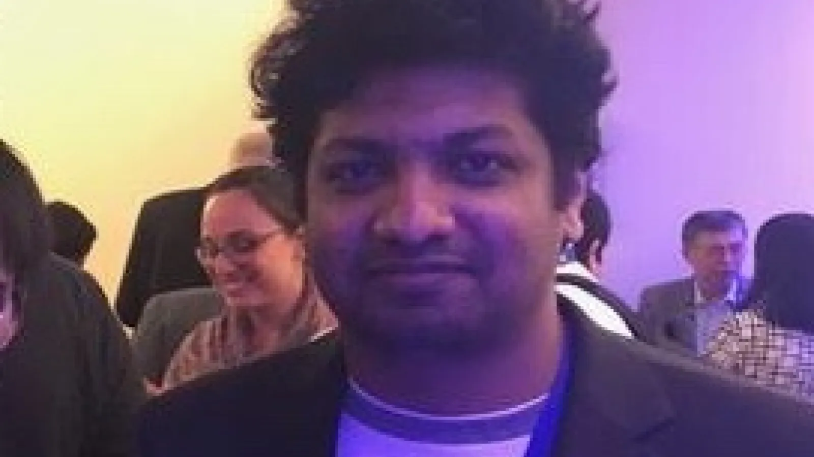 Hiran Wijesinghe in purple lighting at conference