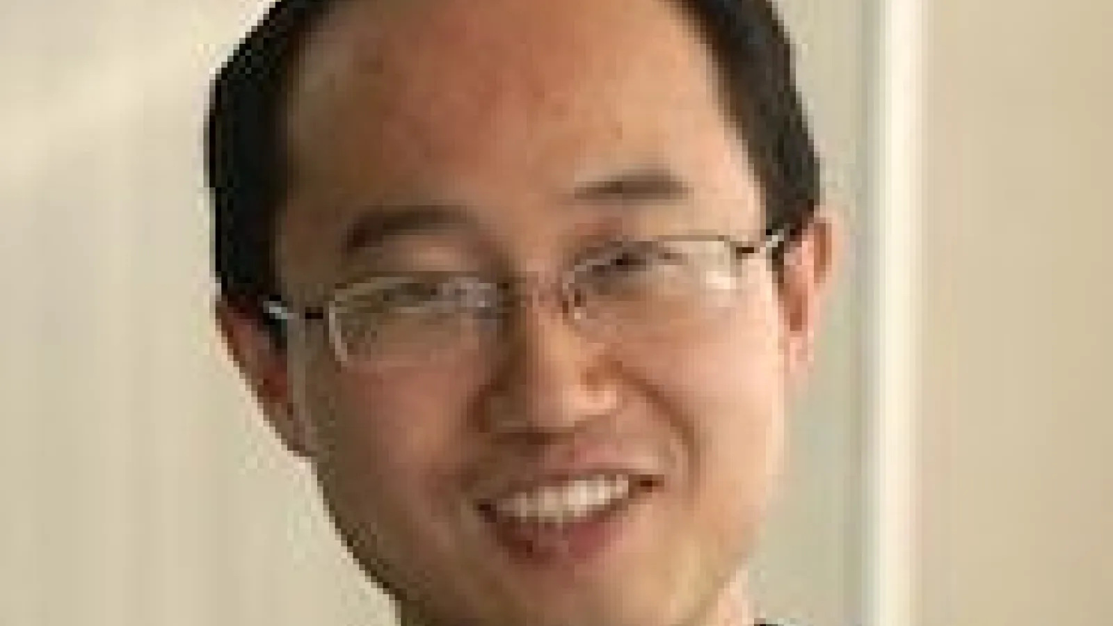 Ning Zhou smiling with beige background