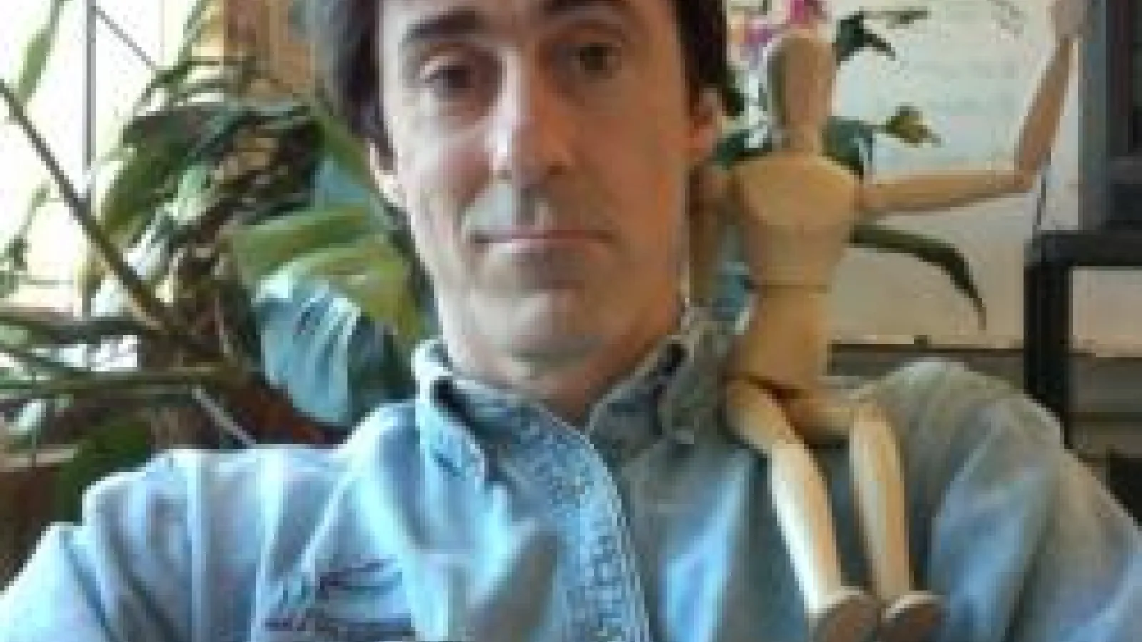 Professor Mike Lisa with a wooden figurine on their shoulder.