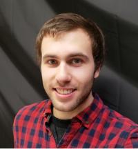 Alex Melendez smiling with black background