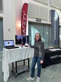 Photo of Kaeli Hughes at Safety and Infrastructure tables in the Atrium