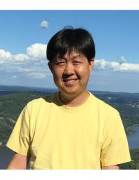 Inhee Lee smiling with open landscape and blue sky behind him