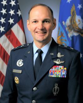 Photo of Major General John Olson with American Flag in the background.