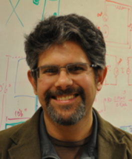 Jay Gupta smiling in front of whiteboard