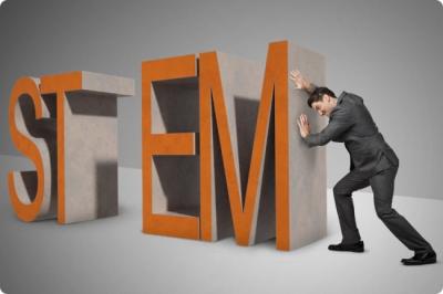 Photo of man pushing giant letters spelling stem, symbolizing him trying to close the "stem gap"