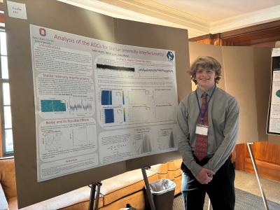 John Scott standing with his research presentation poster