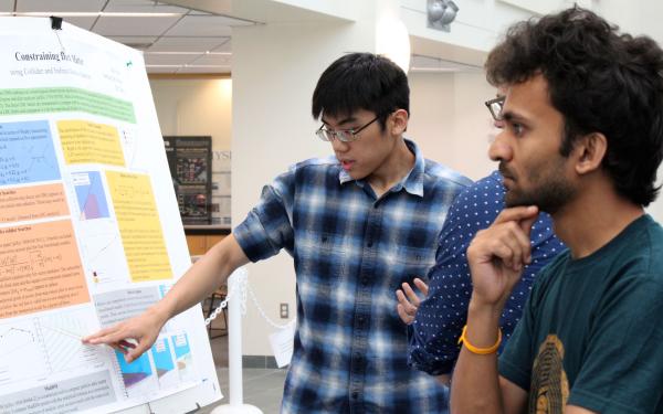 Two students discussing a research poster