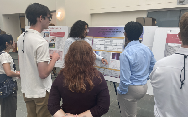 A student presenting their research poster