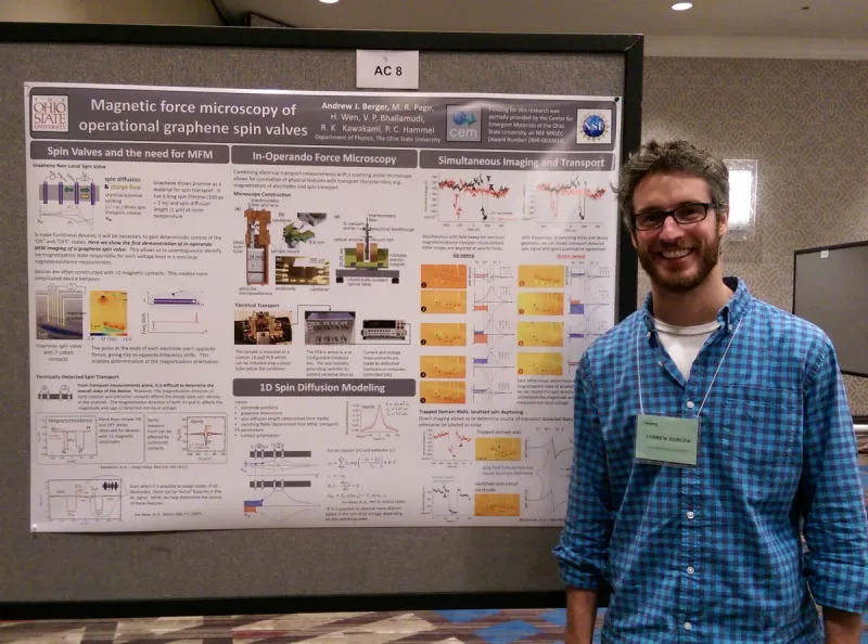 Researcher smiling and standing in front of research poster