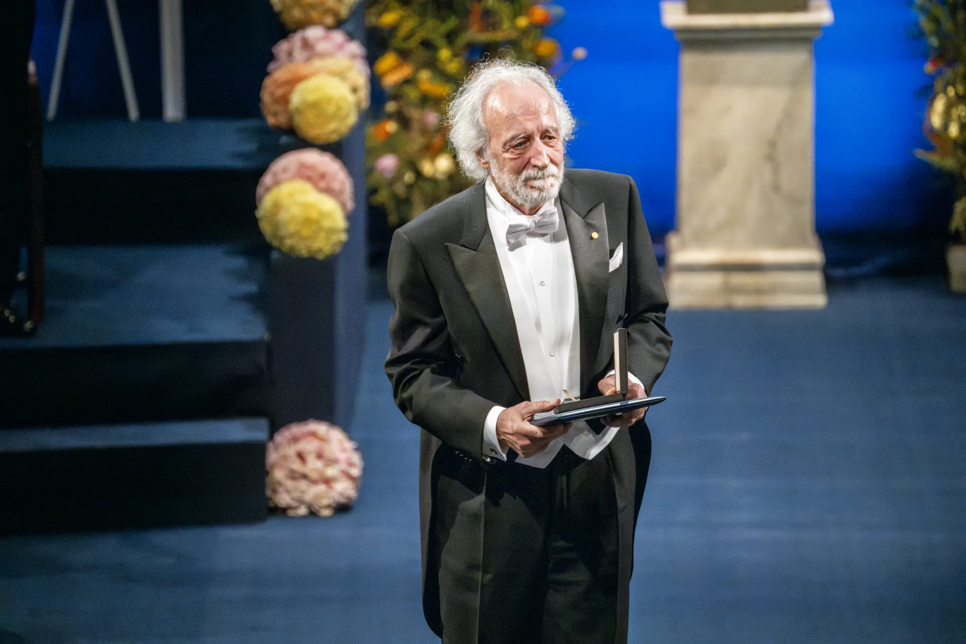 Pierre Agostini holding Nobel Prize in Physics.