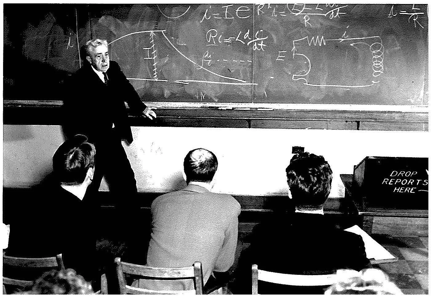 Alpheus Smith lecturing in front of a chalkboard