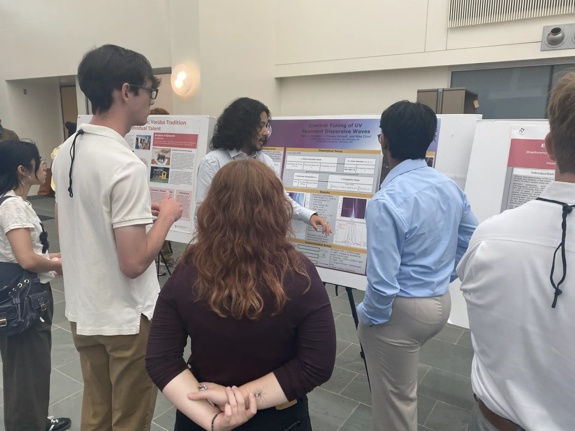 A student presenting their research poster