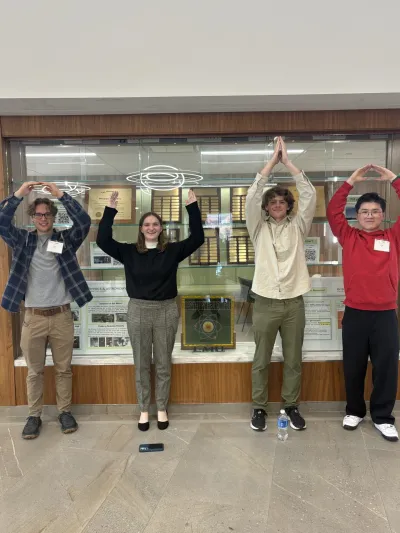 From left to right: Cole Steele, Maggie Ramsey, John Scott, and Tianhao Jin using their arms to spell Ohio at the APS fall meeting.