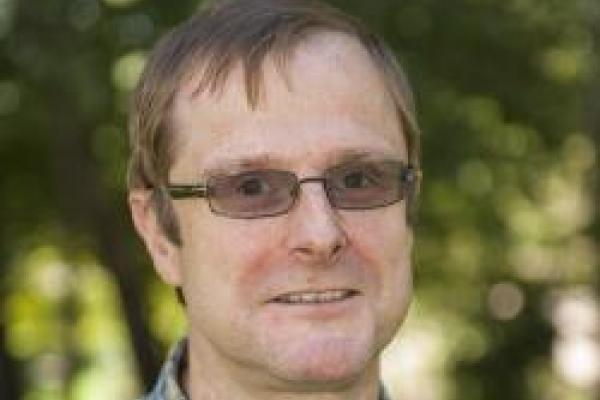 A close-up of Matthias Dietrich with trees in the background.