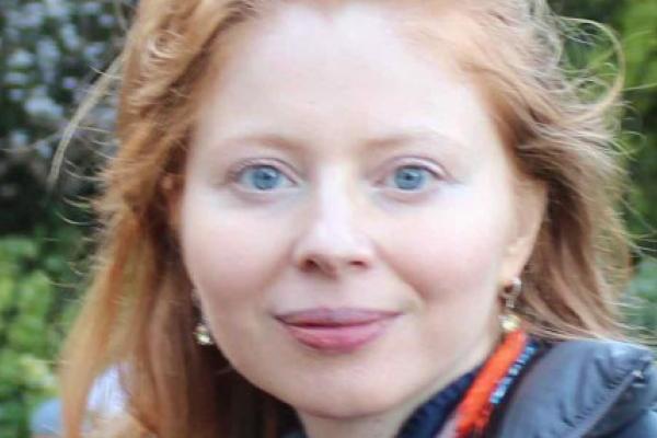 Professor Landsman close up with trees behind her