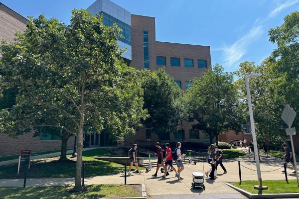 Photo of outside of PRB with students passing. Bright blue sky, sunny day.