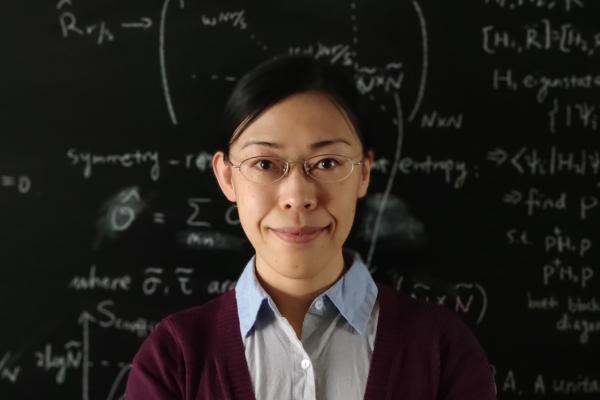 Photo of Laimei Nie in front of a chalkboard
