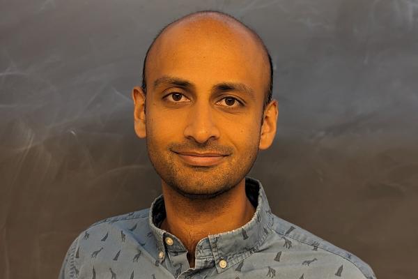 Photo of Rahul in front of a plain chalkboard