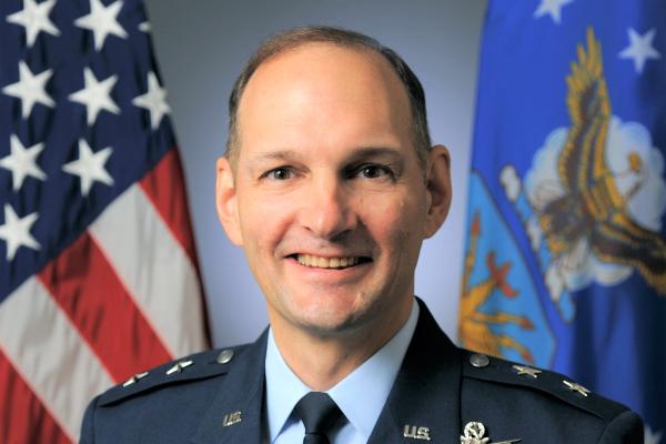 Photo of Major General John Olson with American Flag in the background.
