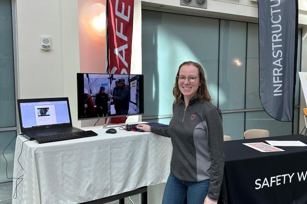 Photo of Kaeli Hughes at Safety and Infrastructure tables in the Atrium