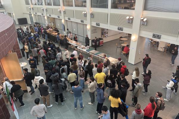 Aerial view looking down on atrium at crowd of students in line for food and to meet Pierre Agostini.