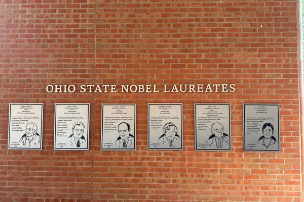 Row of silver Nobel Winner plaques on wall of 18th street library