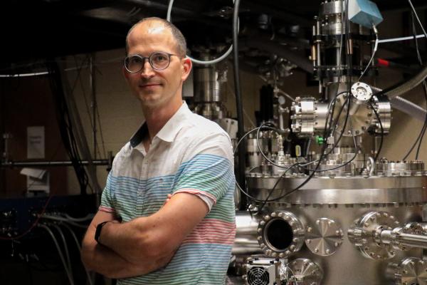 Michael Chini standing with arms crossed in the lab
