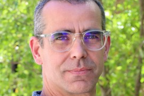 Eric Brewe in front of a line of trees