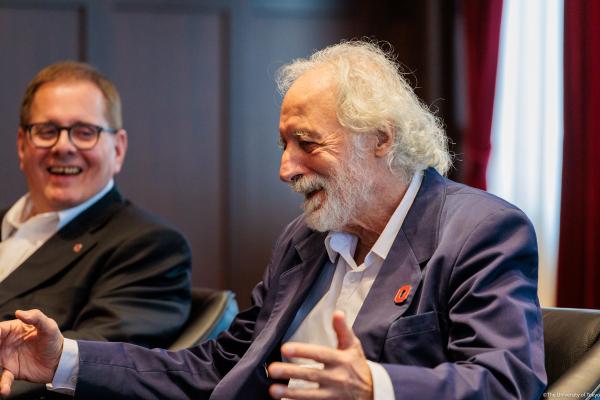 Lou DiMauro and Pierre Agostini laughing and smiling as Pierre speaks