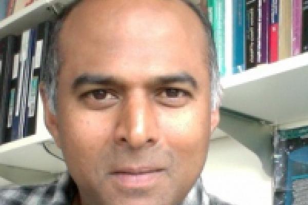 Prof. Reddy in front of a bookcase