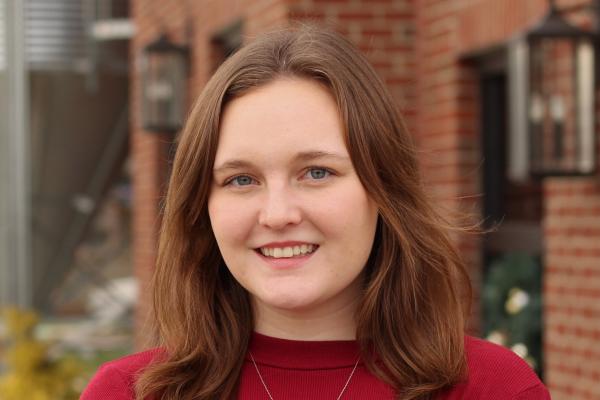 Maura Kelley smiling in front of a brick building
