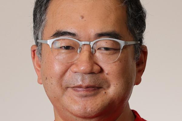 Professor Masaki Oshikawa in front of a white wall