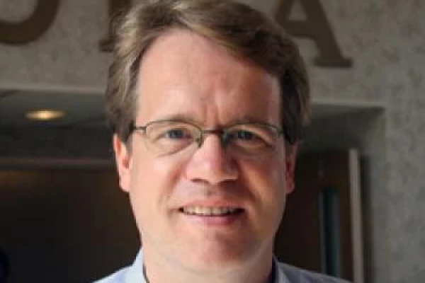 Andreas Becker smiling in front of a doorway