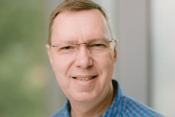 Close up of Professor Gruzberg in front of a window