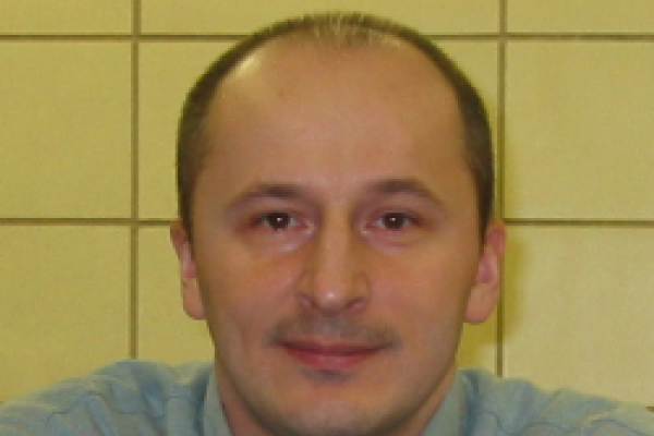 Adam Kaminski sitting in front of yellow wall