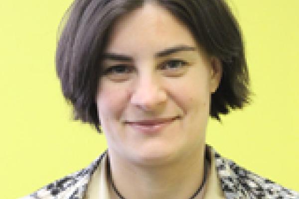 A headshot of Amy Connolly with a yellow background.