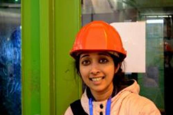 Archana Anandakrishnan smiling in orange hard hat