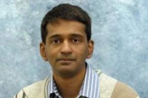 Arun Paramekanti in front of light blue background