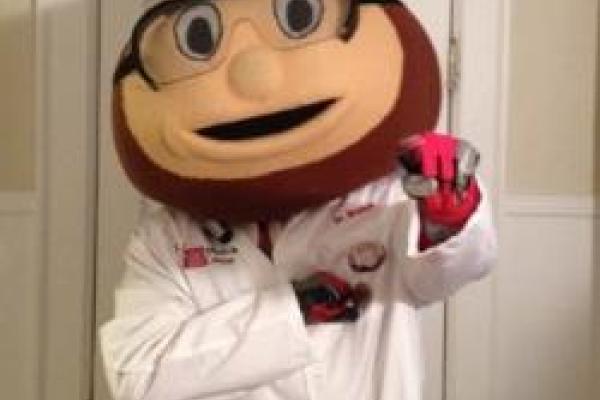 Brutus Buckeye wearing PPE: goggles, lab coat, and gloves.