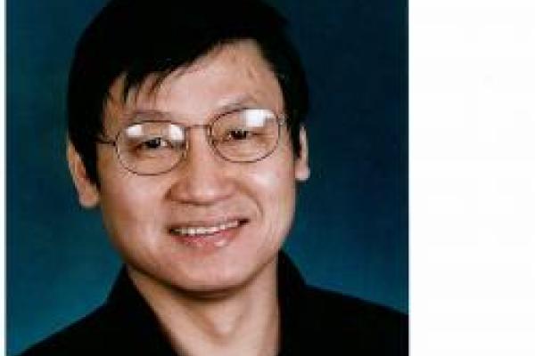 Jason Ho smiling with blue background