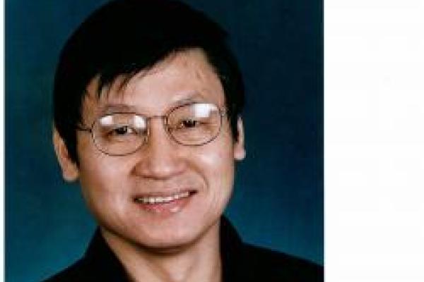 Jason Ho smiling with blue background