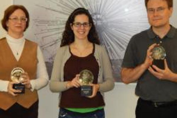 A picture of the staff holding their awards. On the left is Kris Dunlap with Lisa Colarosa in the middle and Eric Robbins on the right.