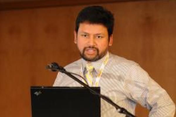 Dr. Enam Chowdhury speaking at podium