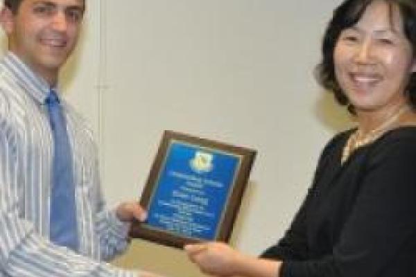 Evan Lang smiling and holding his award