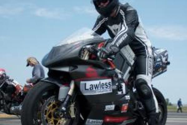 Jenn on electric motorcycle with blue sky behind her